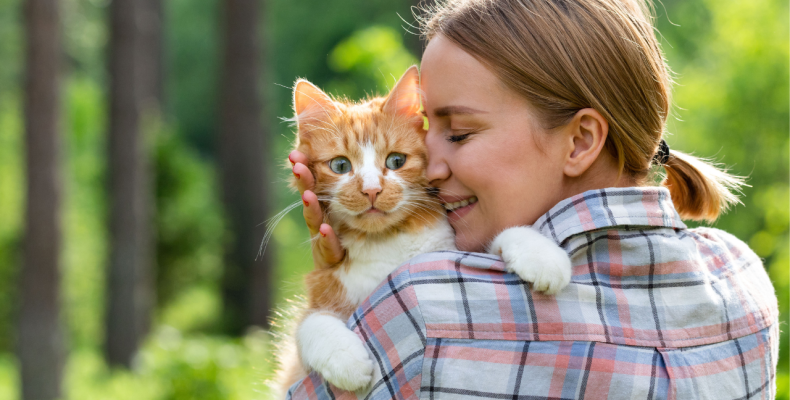 kobieta przytulająca rudego kota
